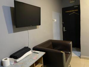 Habitación con silla y TV en la pared en Hotel Global Subang, en Subang Jaya