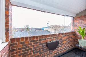 a brick wall with a window on a balcony at Stylish 1BR apt, 7min Archway Tube & Holloway Rd in London