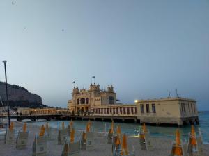 een groep stoelen op een strand naast een pier bij La Casetta del Viale 13 in Palermo