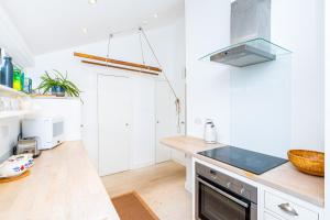 uma cozinha com armários brancos e uma bancada em Stylish 1BR apt, 7min Archway Tube & Holloway Rd em Londres