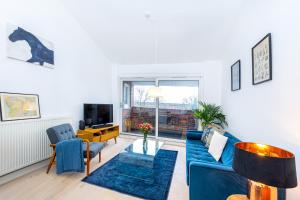 a living room with a blue couch and a tv at Stylish 1BR apt, 7min Archway Tube & Holloway Rd in London