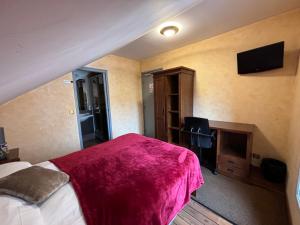 um quarto com uma cama grande e um cobertor rosa em O Barcaiolo em Conflans-Sainte-Honorine