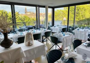 un restaurante con mesas y sillas blancas y ventanas en Residenz am Zwinger en Dresden