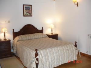 a bedroom with a bed with two night stands and two lamps at Solar Dos Cerveiras in Mesquitela