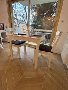 - une table et des chaises en bois dans une chambre avec fenêtre dans l'établissement Studio L'échappée avec parking sous-sol privatif, à Chartres