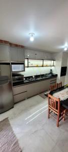 una cucina con elettrodomestici in acciaio inossidabile e panca in legno di Gih Guest House Parque Beto Carrero a Penha