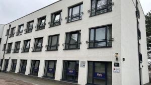 - un bâtiment blanc avec des fenêtres noires dans une rue dans l'établissement MYKY Hotel Boardinghouse, à Hambourg