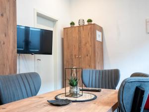 mesa de madera con sillas azules y TV en SR24-Stillvolles gemütliches Apartment 1 in Recklinghausen, en Recklinghausen