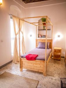 1 dormitorio con 1 cama con marco de madera en Firefly Boutique Lodge en Bagamoyo