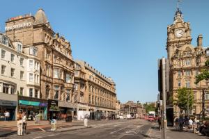 una calle de la ciudad con una torre del reloj y edificios en Hotel Indigo - Edinburgh - Princes Street, an IHG Hotel en Edimburgo