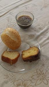 um prato de vidro com dois pedaços de pão e uma chávena de café em Pouso da Lapa em Pirenópolis