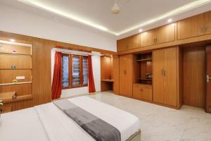 a bedroom with wooden cabinets and a large bed at Woodstone Manor by JadeCaps Penthouse Indiranagar in Bangalore