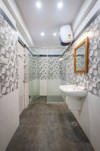 a bathroom with a sink and a shower at Woodstone Manor by JadeCaps Penthouse Indiranagar in Bangalore
