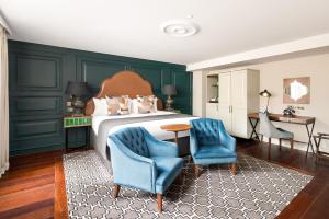 a bedroom with green walls and blue chairs and a bed at Hotel Indigo - Edinburgh - Princes Street, an IHG Hotel in Edinburgh