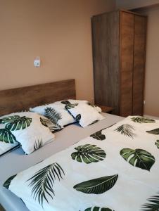 twee bedden in een kamer met bedrukte palmbladeren bij Apartament RESET 2 pokojowy in Ustroń