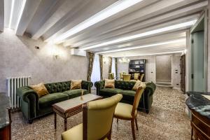a living room with green couches and a table at Cà Rialto 4122 Luxury Terrace in Venice