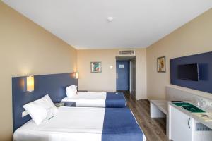 キジラガックにあるWashington Resort Hotel & Spaのベッド2台とテレビが備わるホテルルームです。