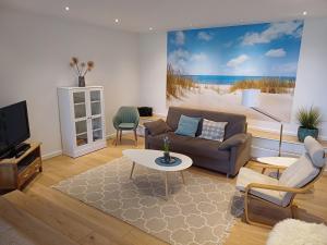 a living room with a couch and a tv at Ferienwohnung am Schöhsee in Plön