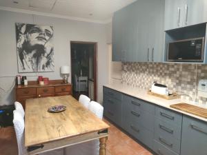 a kitchen with a wooden table in a kitchen at Urban Oasis Cape Town in Cape Town