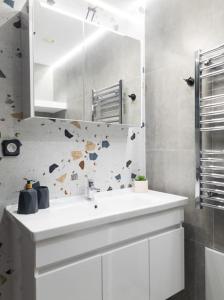 a bathroom with a white sink and a mirror at Camellia Suite - 5 min drive to Piraeus Port in Piraeus