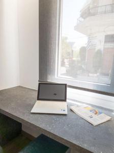 a laptop computer sitting on a counter next to a window at Camellia Suite - 5 min drive to Piraeus Port in Piraeus