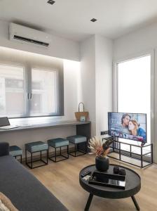 a living room with a couch and a tv at Camellia Suite - 5 min drive to Piraeus Port in Piraeus