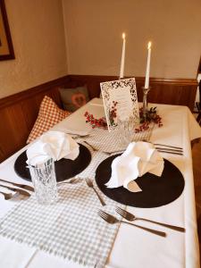 a table with a white table cloth and two hats and silverware at DEVA Hotel Alpenglück in Weißbach