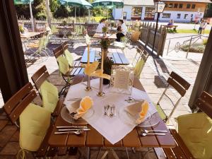 uma mesa de madeira com cadeiras amarelas e um estofados de estesteres em DEVA Hotel Alpenglück em Weißbach