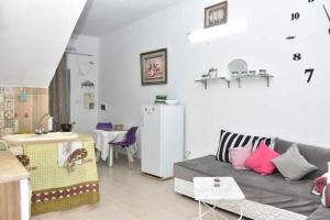 een woonkamer met een bank en een koelkast bij Dar Sobrina in Tozeur