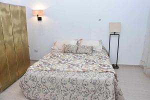 a bedroom with a bed with a comforter and pillows at Dar Sobrina in Tozeur