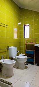 La salle de bains verte est pourvue de toilettes et d'un lavabo. dans l'établissement Chill and Fun - Matosinhos - ONLY ROOM, à Matosinhos