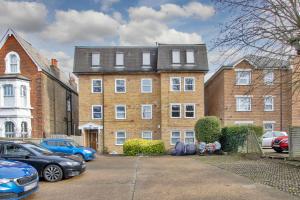 a large brick building with cars parked in a parking lot at Chic 2-bed apartment, free Wi-Fi and parking in Hither Green