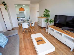 ein Wohnzimmer mit einem Sofa, einem TV und einem Tisch in der Unterkunft Apartment by the Sea by Hello Homes Sitges in Sitges