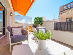a patio with a couch and a table on a balcony at Elite Bonaire Penthouse by Hello Homes Sitges in Sitges