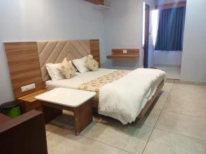 a bedroom with a large bed and a table at Hotel Red Blue,Ahmedabad in Naroda