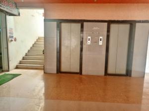 Hotel Red Blue,Ahmedabad في Naroda: صف من أبواب المصاعد في مبنى به درج