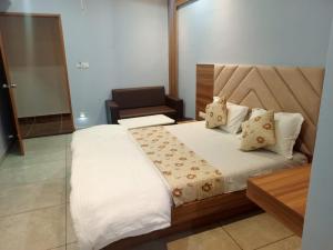 um quarto com uma cama e uma cadeira em Hotel Red Blue,Ahmedabad em Naroda