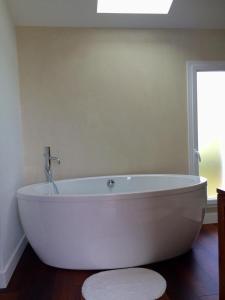 - une baignoire blanche dans une chambre avec fenêtre dans l'établissement Appartement entre mer et montagne, à Ustaritz