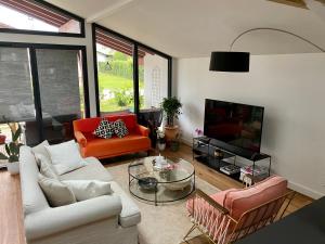 - un salon avec un canapé et une télévision dans l'établissement Appartement entre mer et montagne, à Ustaritz