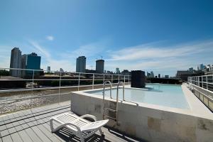 a swimming pool on top of a building with a city at STUDIO MODERNO EN PUERTO MADERO FRENTE AL HOTEL MADERO in Buenos Aires