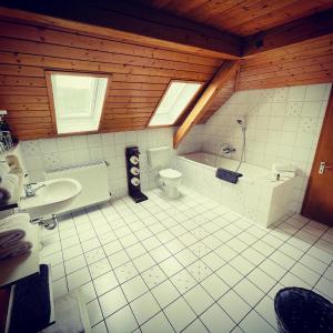a bathroom with a tub and a toilet and a sink at Rayers Boutique-Hotel 