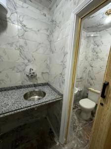 a bathroom with a sink and a toilet at شقه غرفتين جديده وعفش جديد وفرش جديد in Mansoura