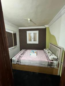a small bedroom with a bed and two windows at شقه غرفتين جديده وعفش جديد وفرش جديد in Mansoura