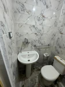 een witte badkamer met een toilet en een wastafel bij شقه غرفتين جديده وعفش جديد وفرش جديد in Mansoura