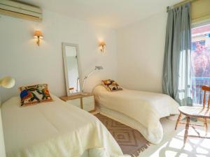 2 camas en una habitación con espejo y ventana en Ocean Spirit House by Hello Homes Sitges, en Sitges