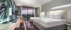 a hotel room with two beds and a balcony at Nirvana Cosmopolitan in Lara