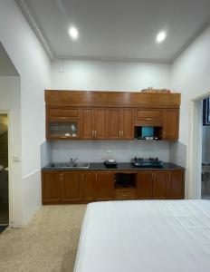 a kitchen with wooden cabinets and a bed in a room at Dodo home XD in Hanoi