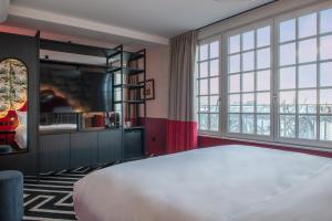 ein Schlafzimmer mit einem großen Bett und großen Fenstern in der Unterkunft LABE Hôtel Tours Centre Gare in Tours