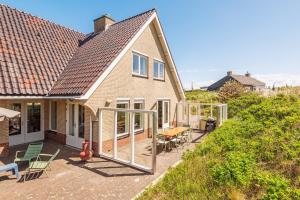 une maison avec des portes coulissantes en verre sur une terrasse dans l'établissement Villa Duin en Strand, à Bergen aan Zee