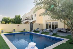 a swimming pool in front of a house at Nasma Luxury Stays - Exquisite 4BR Villa, with a Private Pool in Ras al Khaimah